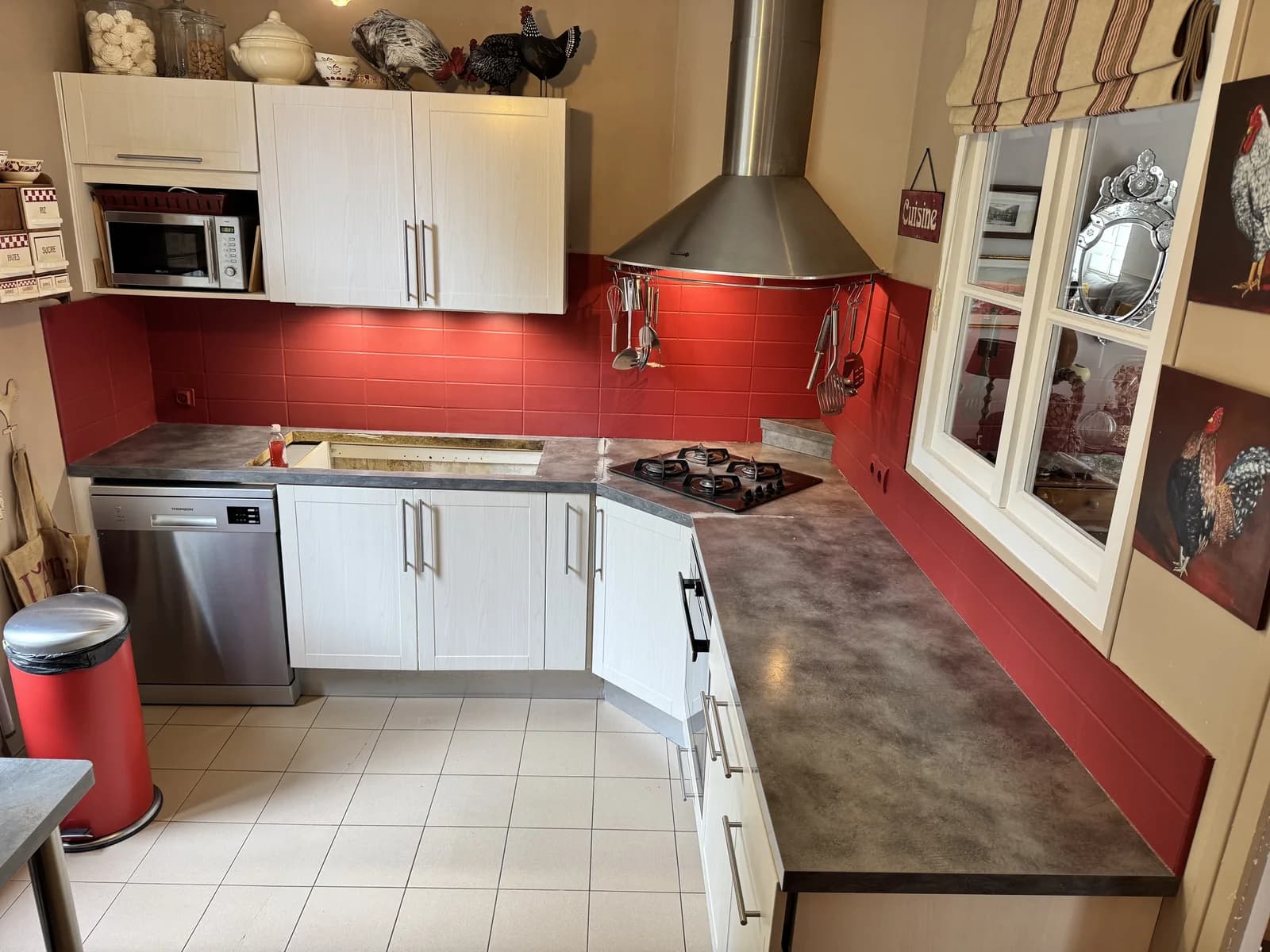 Avant : Cuisine aux meubles clairs avant rénovation du plan de travail à décor minéral sombre.